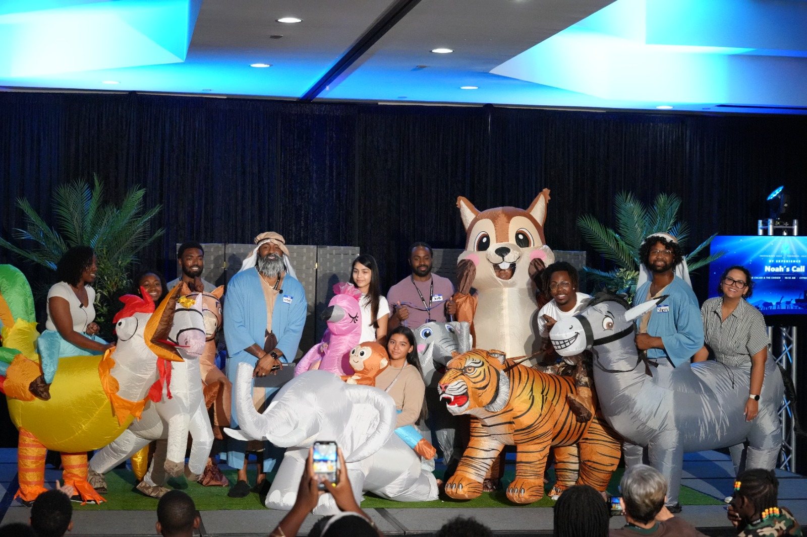 The Noah's Call company on stage in inflatable animal costumes beside Noah