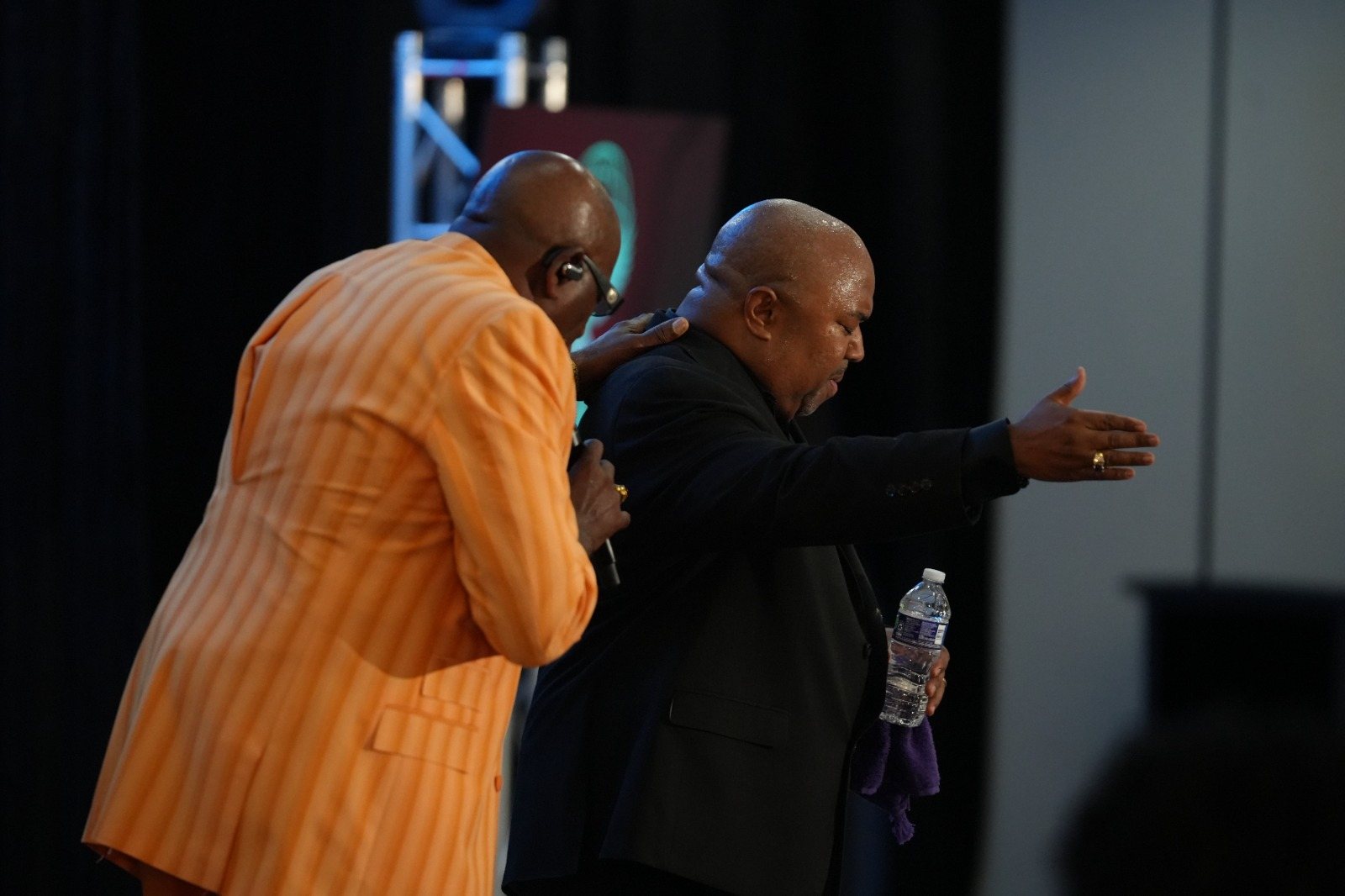 Ministers pray with attendees at the front of the ballroom