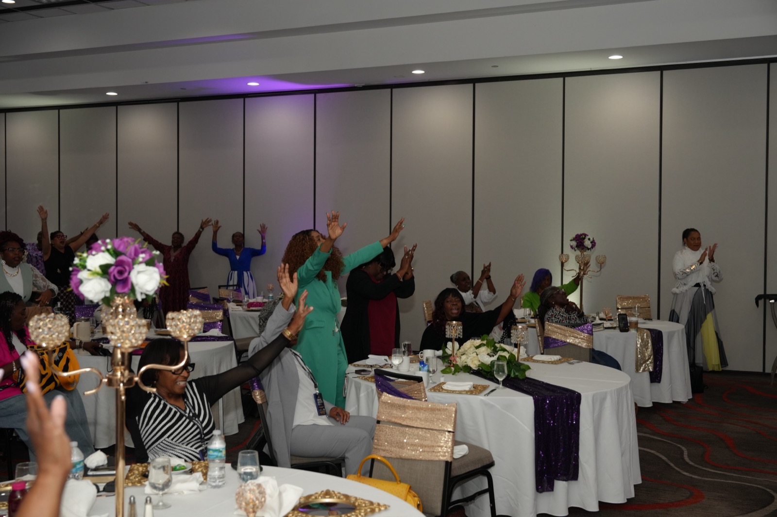 Women worship together around tables during the Women of Wisdom gathering